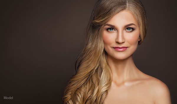 elegant headshot of a woman with long hair over her bare shoulders